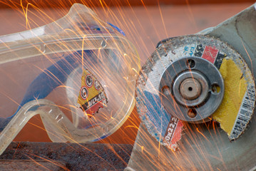 An element of a detachable abrasive disk stuck in goggles while working with a catch grinder