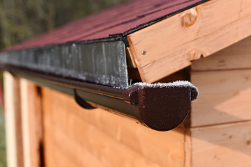 Modern roof shingles tiles. Soft asphalt roof cover and roofing construction for a small house in the garden. Easy roofing repair. Czech republic, Europe.