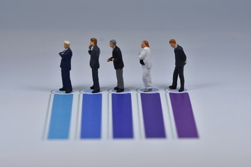 Mini business men standing on paper with blua and purple lines printed on it