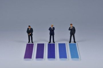Fototapeta premium Mini business men standing on paper with blua and purple lines printed on it