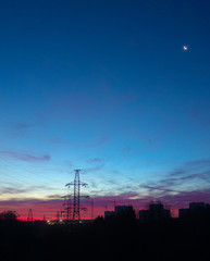 Power lines on a pink sky background. Sunrise over the forest