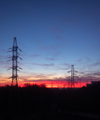 Power lines on a pink sky background. Sunrise over the forest