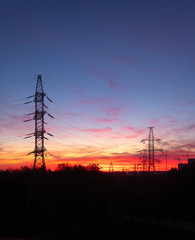 Power lines on a pink sky background. Sunrise over the forest