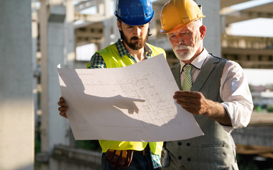 Architect and construction engineer or surveyor discussion plans and blueprints