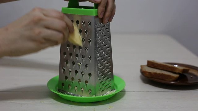 Hands grating cheese. Close-up footage.