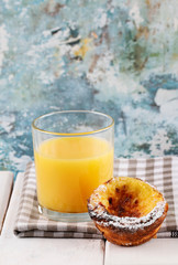 Homemade version of spanish sweet dessert called Crema Catalana and glass of orange juice.