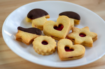 Christmas linzer sweets and cookies made from shortcrust pastry, various shapes filled with marmalade, decorated with chocolate