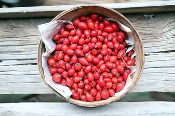 Ripe rosehips or wild rose berries on a natural wooden background