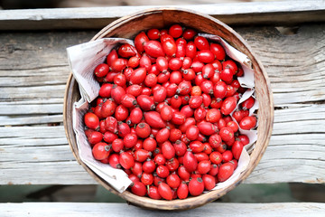 Ripe rosehips or wild rose berries on a natural wooden background
