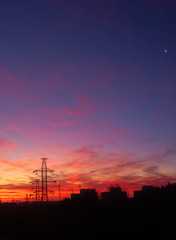 Naklejka premium Power lines on a pink sky background. Sunrise over the forest