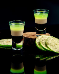 a glass of alcoholic drink and apple slices sprinkled with pepper