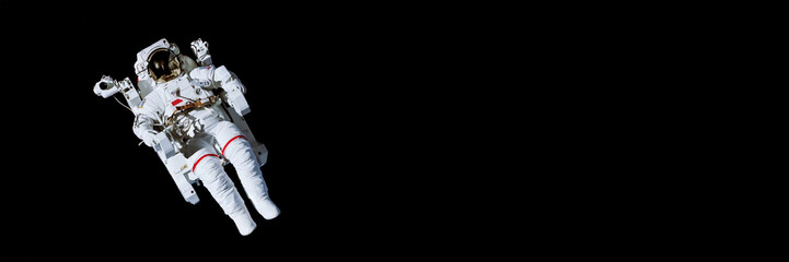 Astronaut with a jetpack isolated on black panoramic background with copy space -  Elements of this image are furnished by NASA © Delphotostock