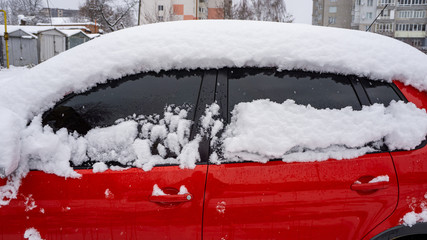 The car, covered with thick layer of snow. Negative consequence of heavy snowfalls. Side hundred...