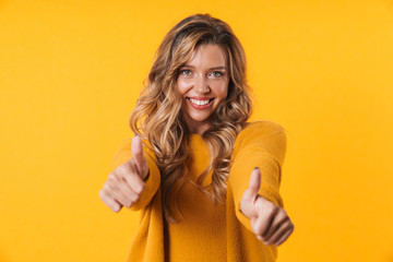Image of blonde woman in warm sweater laughing and showing thumbs up