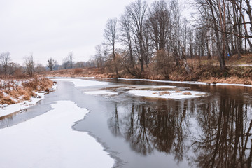 Fototapeta na wymiar A river covered by snow and ice. Winter landscape