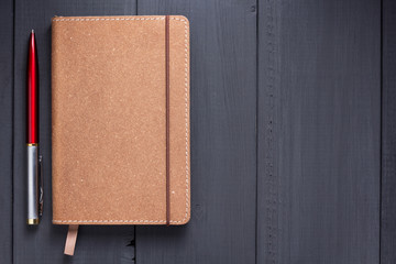 notepad and pen at black wooden background surface table