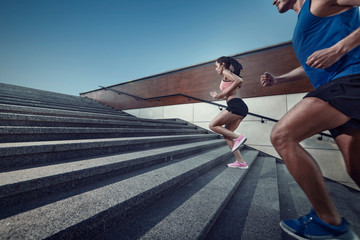 Athletic young people jogging on a stairs.