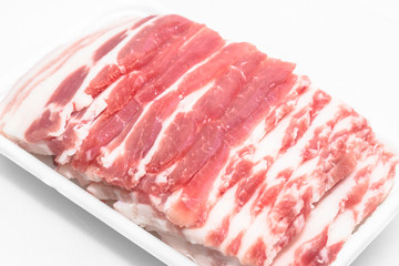 Sliced pork belly on a white background