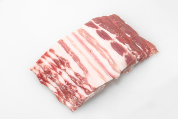 Sliced pork belly on a white background