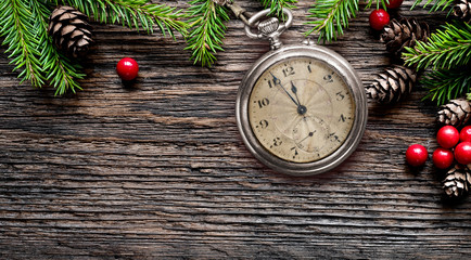 New Year old pocket watch eve to midnight with fir branches background