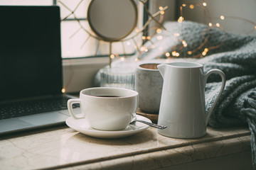 Cozy freelancer's winter work place at home with cup of coffee