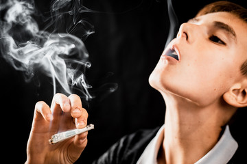 A teen Smoking a cigarette or drugs is a rolled dollar, the concept of teen addiction and spending...