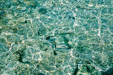 Natural background - sea stones in transparent ripples of water