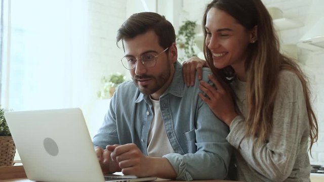 Overjoyed young couple using laptop excited by online win