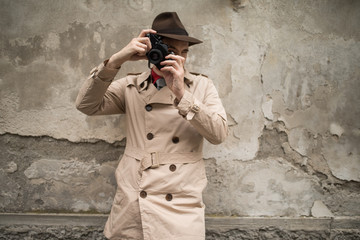 Spy or paparazzo photographer, man using camera in a city street
