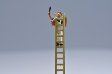 tiny painters are painting. Standing on a ladder, walking around brushes