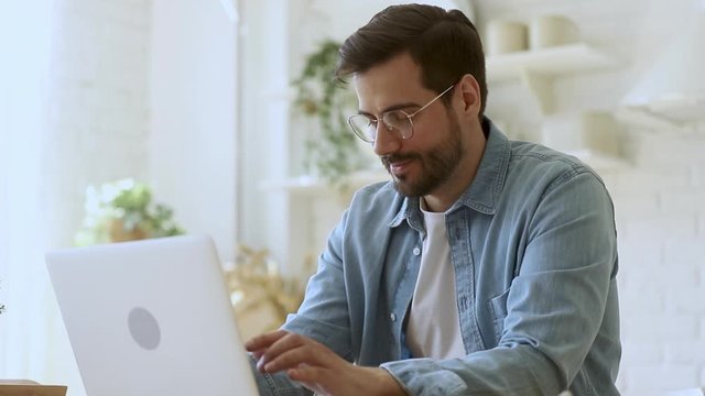 Young man freelancer using laptop studying working online at home