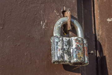 Old steel padlock securely locks the hangar gate