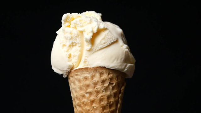 Vanilla ice cream scoop in waffle cone on black background, Closeup Front view, Food concept, Blank for design.