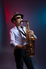 Fototapeta na wymiar Young boy playing saxophone like a pro