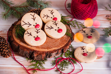 Beautiful tasty homemade cookie in the form of a muzzle of a deer on a wooden tray. Christmas food