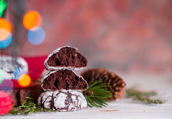 Tasty and fragrant chocolate chip cookies are crushed with powdered sugar, with multi-colored lights on the table.