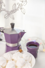 Coffee mug, coffee pot, lanterns, marshmallows on a wooden window sill