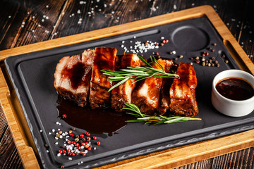 American food concept. Grilled pork ribs with grilled sauce, with smoke, spices and rosemary. Background image. copy space