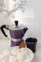 Coffee mug, coffee pot, lanterns, marshmallows on a wooden window sill