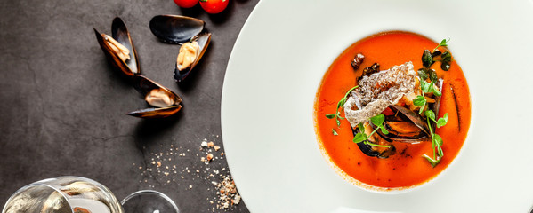 Spanish food concept. Gazpacho tomato soup with seafood, mussels and white wine. Background image. ...