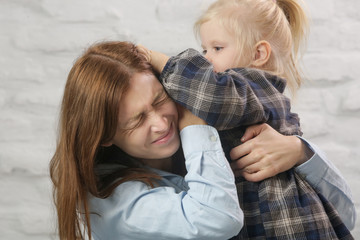 Little toddler girl pulling her mother hair
