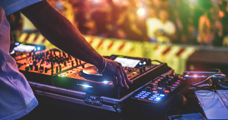 Dj mixing outdoor at new year party festival with crowd of people in background - Nightlife view of disco club outside - Soft focus on bracelet, hand - Fun ,youth,entertainment and fest concept - obrazy, fototapety, plakaty