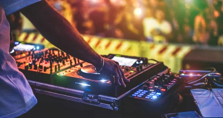 Fototapeten DJ-Mixing im Freien beim Neujahrsparty-Festival mit Menschenmenge im Hintergrund - Nachtleben-Ansicht des Disco-Clubs draußen - Weicher Fokus auf Armband, Hand - Spaß, Jugend, Unterhaltung und Festkonzept © DisobeyArt