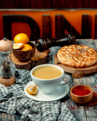 lentil soup with lemon slice and bread on a wooden board