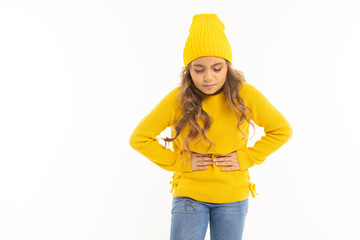 European attractive girl in yellow hat holds on to a stomach on a white background