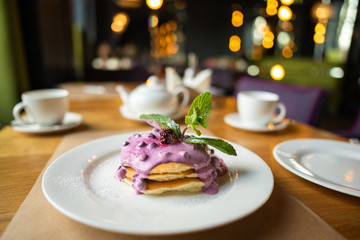 Homemade pancakes with berry sauce, mint and currant sauce