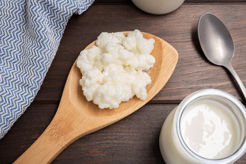 Milk kefir grains in spoon on wooden table