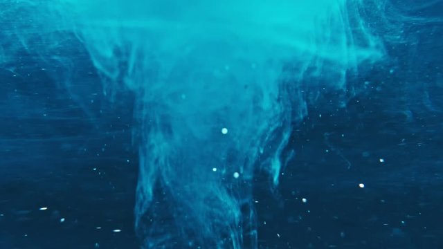 Paint fall into water which is twist. Spin acrylic ink drip into liquid. Visual effect bullet time, frozen moment, flow motion. Cloud fraction of color is spray drop. Slow motion cosmic video magic.