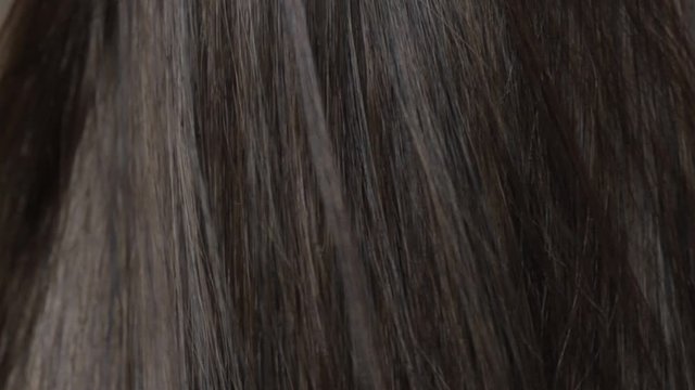 Close-up beautiful long smooth straight brown hair texture. Haircare concept, extensions, hair abstract background. HD video.