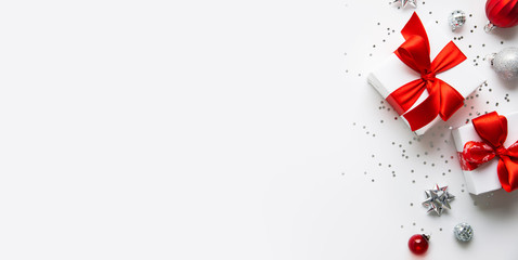 Christmas and New Year holiday background. Xmas greeting card. Christmas red ribbon gifts and ornaments on white background top view